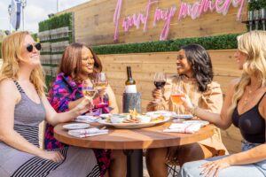 AVA Rooftop Bar's Reopening Weekend in Cary. Ladies having wine and cocktails on the rooftop.